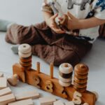 A child engaged in fun learning with a wooden stacking toy and blocks for imaginative play.